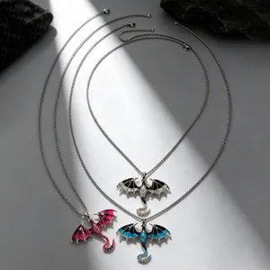 Close-up detail of three gothic flying dragon necklaces in pink blue and white enamel finish