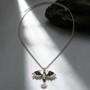 Detailed shot of a vintage gothic dragon pendant necklace with black enamel wings
