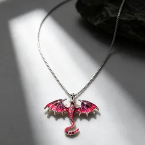 Close-up of gothic red dragon pendant with intricate wing details and silver chain.