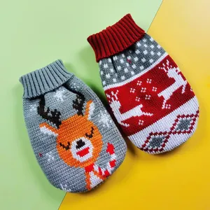 Detail view of two Christmas pet sweaters with knitted reindeer patterns on a bicolor background