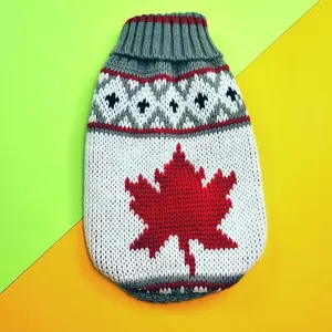 Close-up detail of a knitted fall winter pet sweater with a vibrant red maple leaf pattern.