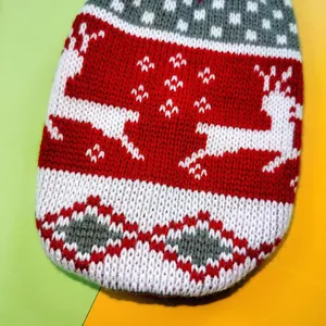 Detailed macro view of red and white knitted Christmas pet sweater with reindeer pattern