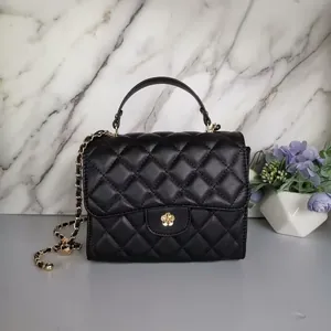Elegant black quilted mini handbag with gold chain strap and floral metal clasp.