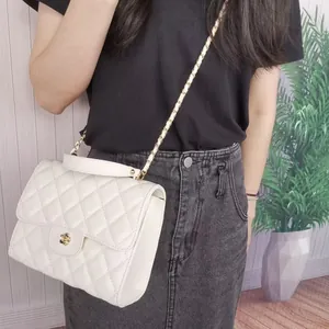 Detailed view of stylish white quilted crossbody bag featuring elegant gold chain strap