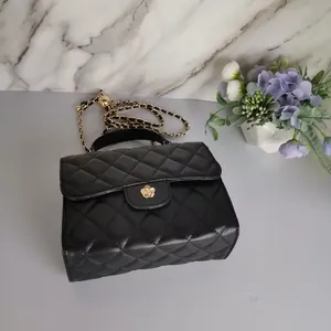 Elegant black quilted mini handbag featuring a gold-tone flower clasp and chic chain strap