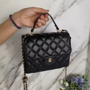 Elegant black quilted mini crossbody bag with gold chain strap and floral metal clasp detail