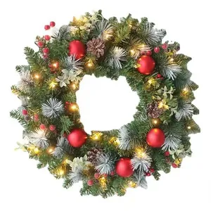Artificial pre-lit Christmas wreath with pine cones and red ornaments on white background