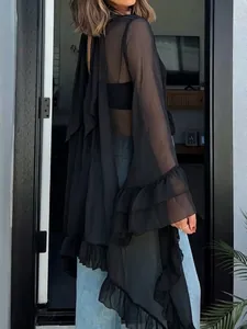 Detail view of a sexy black sheer halter neck cape blouse with elegant ruffle sleeves.