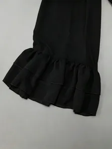 Close-up detail of black sheer fabric featuring an elegant double-layered ruffled hem design