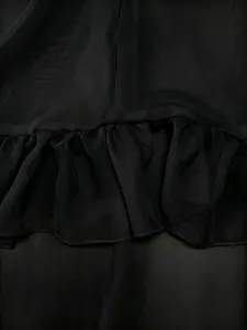 Detailed macro view of black sheer chiffon fabric with elegant ruffled edges and fine stitching