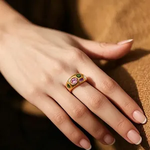 Close-up of vintage 18k gold plated titanium ring with multi-color zircons on hand