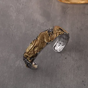 Detailed view of a vintage titanium steel dragon cuff bracelet with golden relief