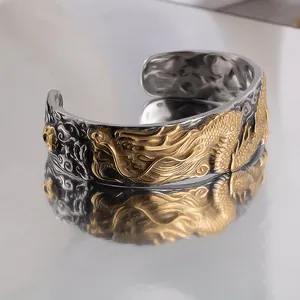 Close-up of vintage titanium steel dragon relief cuff bracelet with gold and silver finish