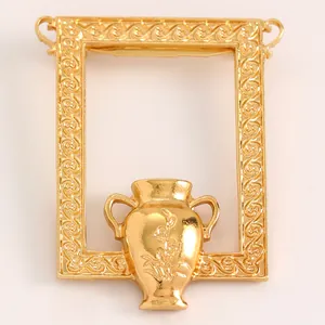 Artistic gold-tone brooch featuring a vintage picture frame and flower vase design.