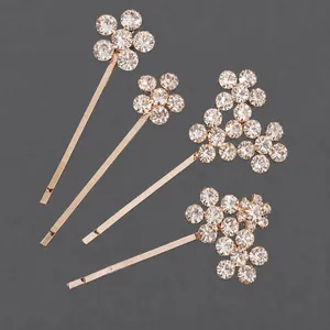 Elegante set de cuatro pasadores dorados con motivos de flores de strass brillantes