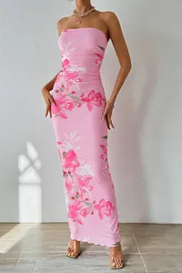 Détail de la robe longue en mesh rose à fleurs sans bretelles pour un look de plage chic.