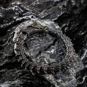 Detailed macro view of vintage punk dragon head bracelet with green eyes and gold horns.