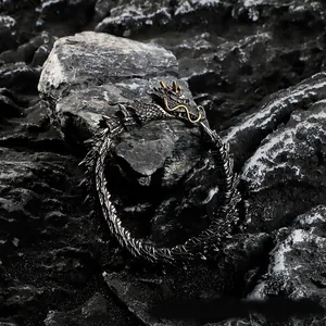 Detailed view of the dark vintage punk dragon scale bracelet on a rugged rock background