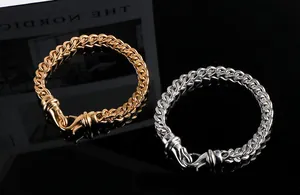 Macro detail view of gold and silver titanium steel cuban link bracelets for men.