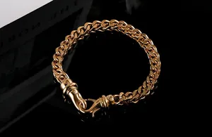 Close-up of chunky gold-plated titanium steel bracelet for men on a black background