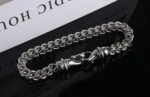 Close-up detail of silver titanium steel curb chain bracelet with large lobster clasp