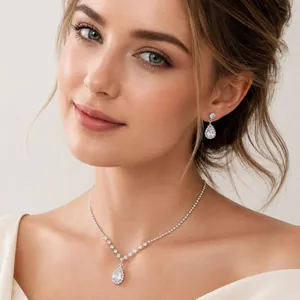 Detailed view of elegant teardrop necklace and earring set on a model, bridal style.