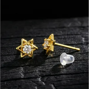 Vue détaillée des boucles d'oreilles hexagramme dorées avec un centre en zircon brillant