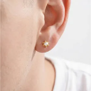 Élégante boucle d'oreille puce hexagramme plaquée or avec zircone portée sur une oreille