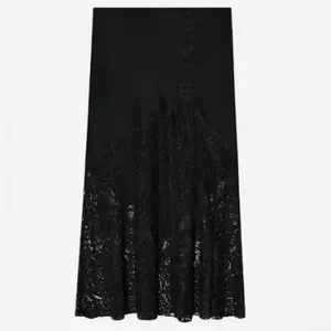 Detail view of black satin midi skirt with exquisite floral lace patchwork.