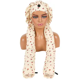 Cremefarbene Schlafmütze für lange Zöpfe mit Kirschmuster und Knopf auf Mannequin-Kopf