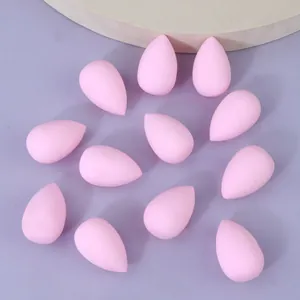 Set mit rosa Mini-Tropfen-Make-up-Schwämmen, latexfreie Blender auf lila Hintergrund.
