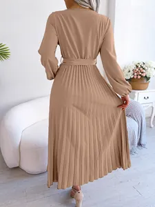 Back view of elegant long-sleeved pleated maxi dress in camel with waist belt detail