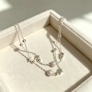 Detailed shot of double-layered silver bracelet with stars and frosted beads in a jewelry box