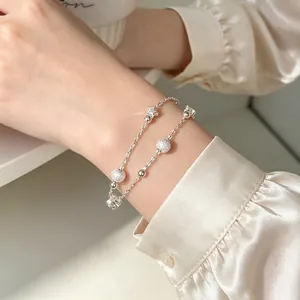 Elegant silver-colored double-layer bracelet with star and frosted ball charms on wrist