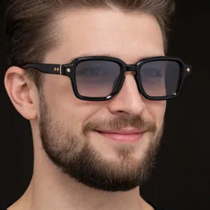 Close-up view of men's black square sunglasses with gradient lenses worn by model