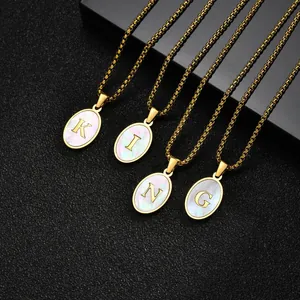 Detail view of oval stainless steel necklaces with white shell letter pendants