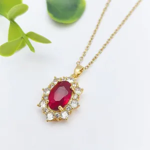 Elegante collana dorata con pendente ovale in pietra rossa e alone di zirconi bianchi