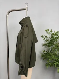 Side profile detail of a stylish olive green short trench coat with buttoned epaulettes