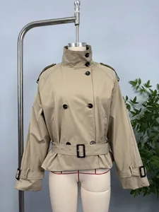 Detail view of khaki short trench coat featuring double-breasted buttons and waist belt