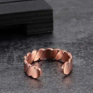 Macro detail of a vintage reddish-copper magnetic ring featuring a braided twist pattern