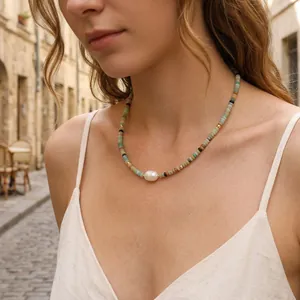 Detail shot of bohemian beaded necklace with central pearl on model outdoors