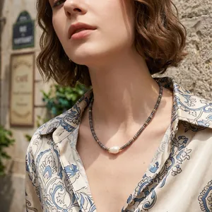 Close-up of a bohemian tiger eye beaded necklace with a lustrous central pearl