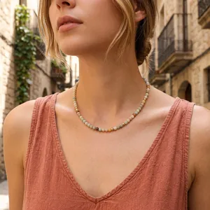Detail view of a bohemian beaded necklace with natural gemstones worn by a model in a street