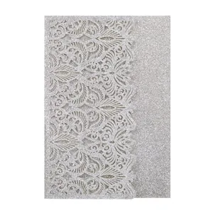 Detail of silver glitter laser-cut wedding invitation with elegant floral pattern.