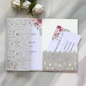 Detailed view of silver glitter laser-cut wedding invitation card with floral insert