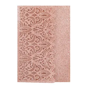 Close-up of laser-cut rose gold glitter invitation card with floral hollow pattern