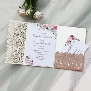 Detail of laser cut wedding invitation with rose gold glitter and floral patterns