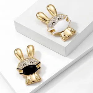 Close-up of cute gold-colored rabbit brooches with sparkling rhinestones and mask design