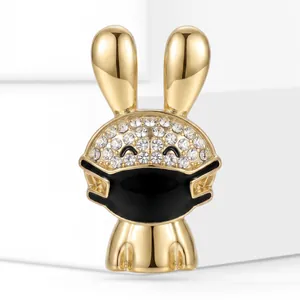 Detail of a golden bunny brooch with sparkling rhinestones and a black mask design
