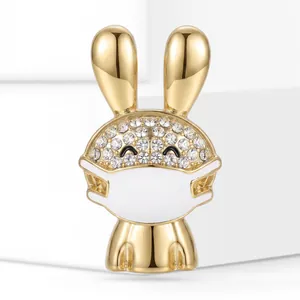 Macro detail showing the sparkling rhinestones and golden finish of the rabbit mask brooch.